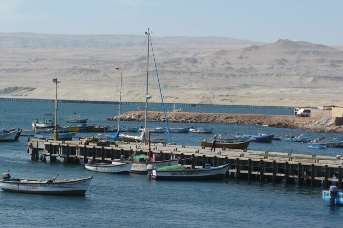 Shougang renuncia a sus derechos mineros en la bahía y destraba el puerto de Marcona, de US$404,8 millones Muelle de pescadores en la bahía de San Juan de Marcona, con el muelle minero y el desierto al fondo