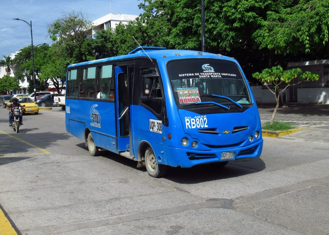 Buseta azul del Sistema de Transporte Unificado de Santa Marta circulando por una avenida arbolada