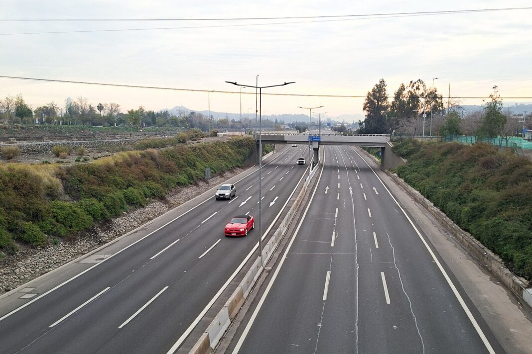 Autopista Costanera Norte en Vitacura, Santiago, con pocos autos y los cerros al fondo