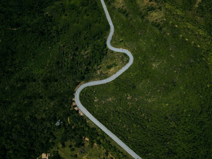 Un ómnibus de turismo volcó en la Curva da Ferradura de la BR-262: tres muertos, 44 heridos y la PRF investiga si se quedó sin frenos Vista aérea de una carretera de sierra con curvas entre vegetación en Minas Gerais