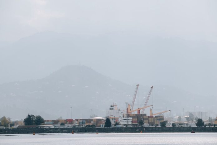 La niebla cerró más de seis horas el canal del Porto de Santos y obligó a cancelar 27 vuelos en Congonhas Puerto con grúas y contenedores bajo la niebla, con cerros al fondo
