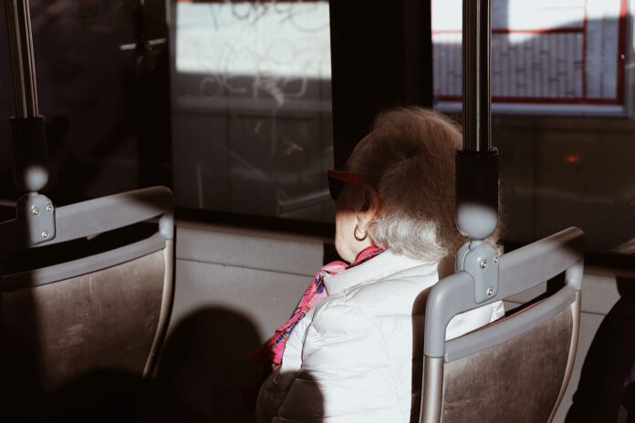 Los viajes gratis de los adultos mayores le costaron ₡14.000 millones al bus en Costa Rica, y el CTP niega que vaya a recortar el beneficio Mujer mayor sentada en un asiento de autobús urbano iluminado por el sol