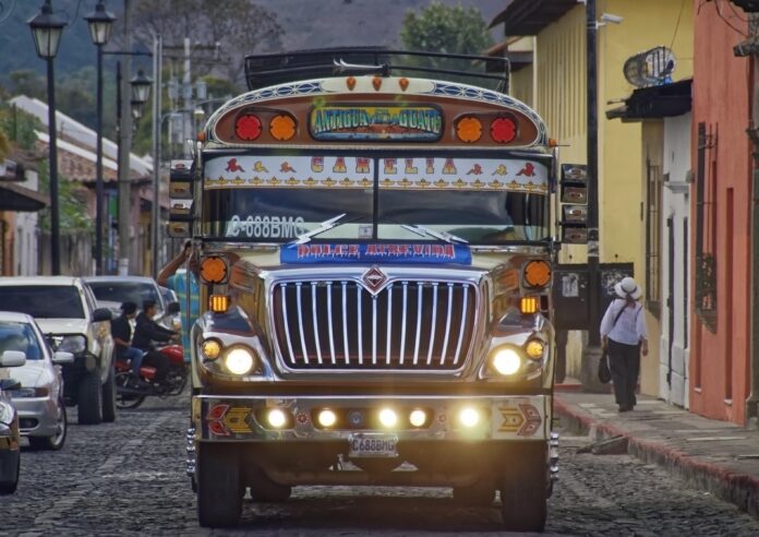 Arévalo ya tiene los dos decretos de combustibles: la carga le pide cuidar el crédito del IVA y los buses, un diésel a Q35 Bus extraurbano decorado con el letrero Antigua-Guate en una calle empedrada