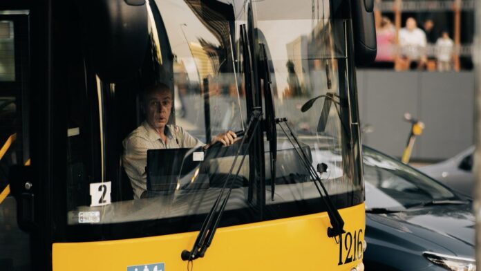 Honduras instala los primeros GPS con botón de pánico en buses urbanos y promete llegar a todas las rutas Conductor al volante de un autobús urbano visto a través del parabrisas