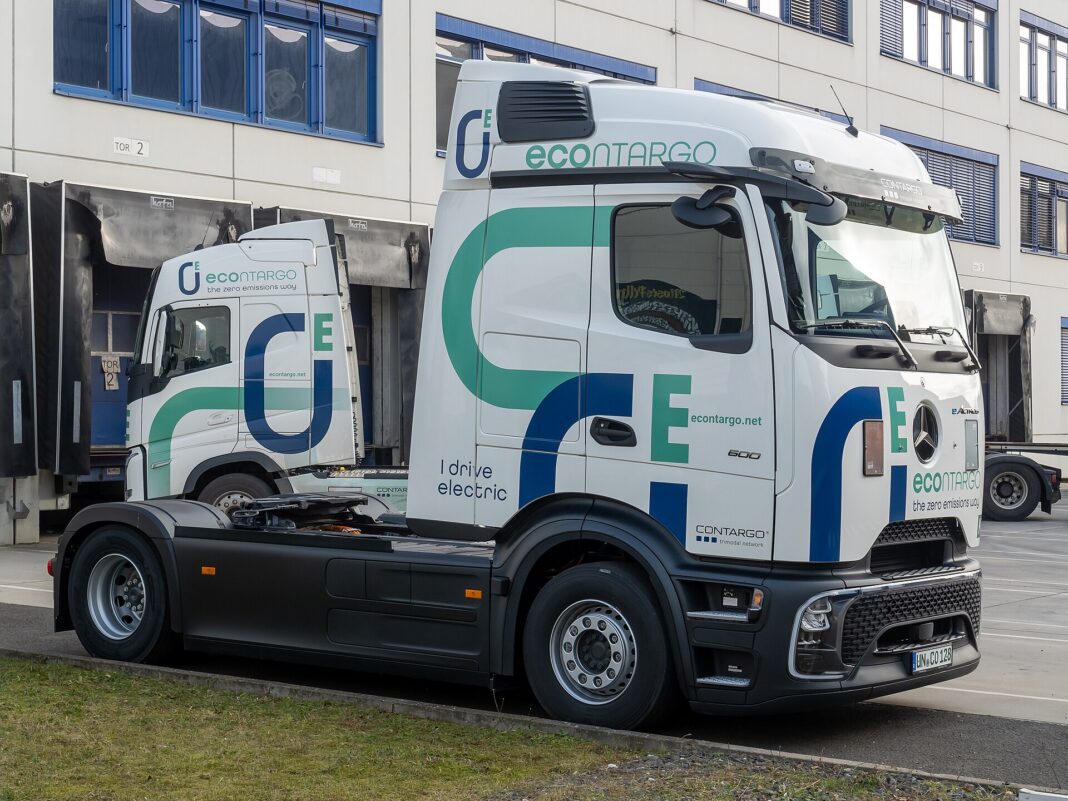 Tractocamión eléctrico Mercedes-Benz eActros 600 estacionado frente a un centro logístico