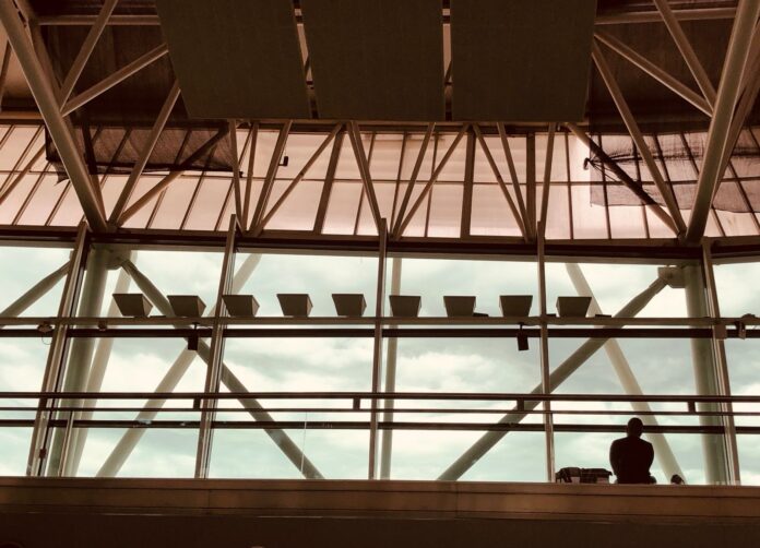 Aeropuertos Argentina suma 11 años de concesión hasta 2049 a cambio de US$600 millones en obras que el Gobierno todavía no detalló Interior de la terminal del aeropuerto de Ezeiza con su estructura metálica y un pasajero junto al ventanal