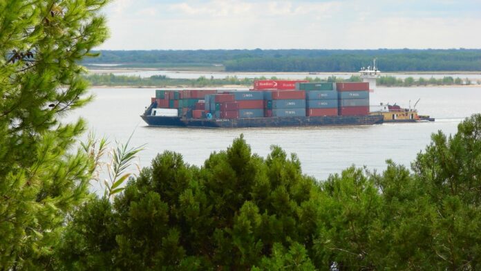 Bolivia, Paraguay y Uruguay reactivan Urupabol tras más de una década: la hidrovía encabeza sus ocho acuerdos Convoy de barcazas cargado con contenedores navegando por un río de la hidrovía