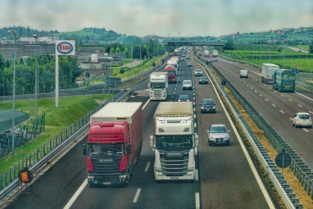 Camiones y coches en una autopista europea junto a una estación de servicio