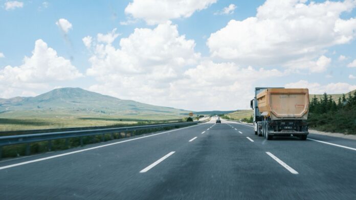 La Plataforma lleva a Óscar Puente su propio real decreto: multas de hasta 4.000 euros por pagar portes por debajo del coste Camión con semirremolque basculante circulando por una autovía con el cielo despejado