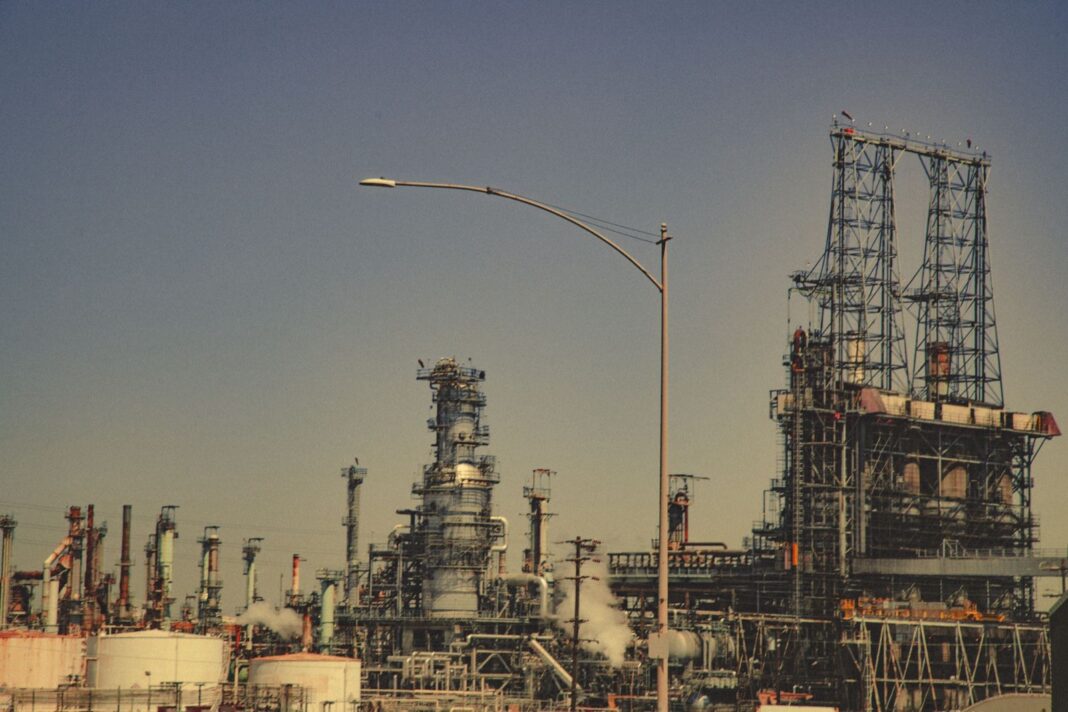 Torres y tanques de una refinería de petróleo bajo un cielo despejado
