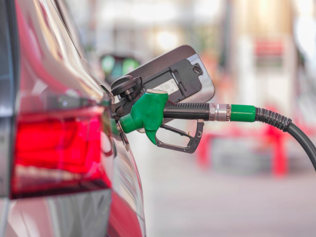 Pistola de combustible verde cargando gasolina en un auto