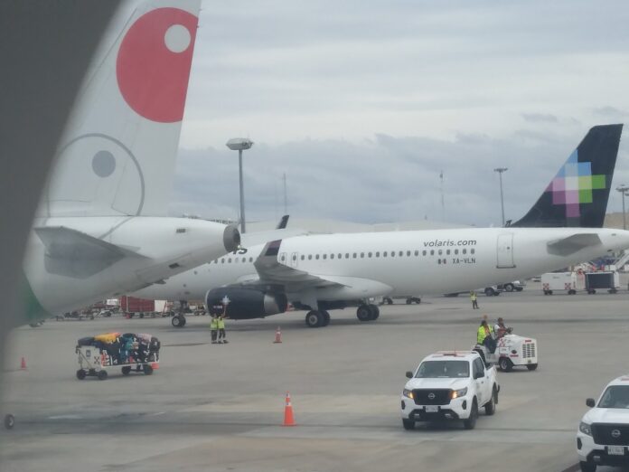 Volaris y Viva sumarían 73% de los vuelos nacionales: llegan las advertencias y la Comisión Antimonopolio sigue sin resolver la fusión Cola de un avión de Viva Aerobus junto a un Airbus de Volaris en la plataforma del aeropuerto de Cancún