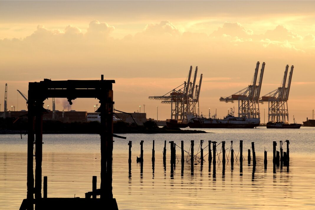 Grúas de contenedores del puerto de Montevideo al atardecer, vistas desde la bahía