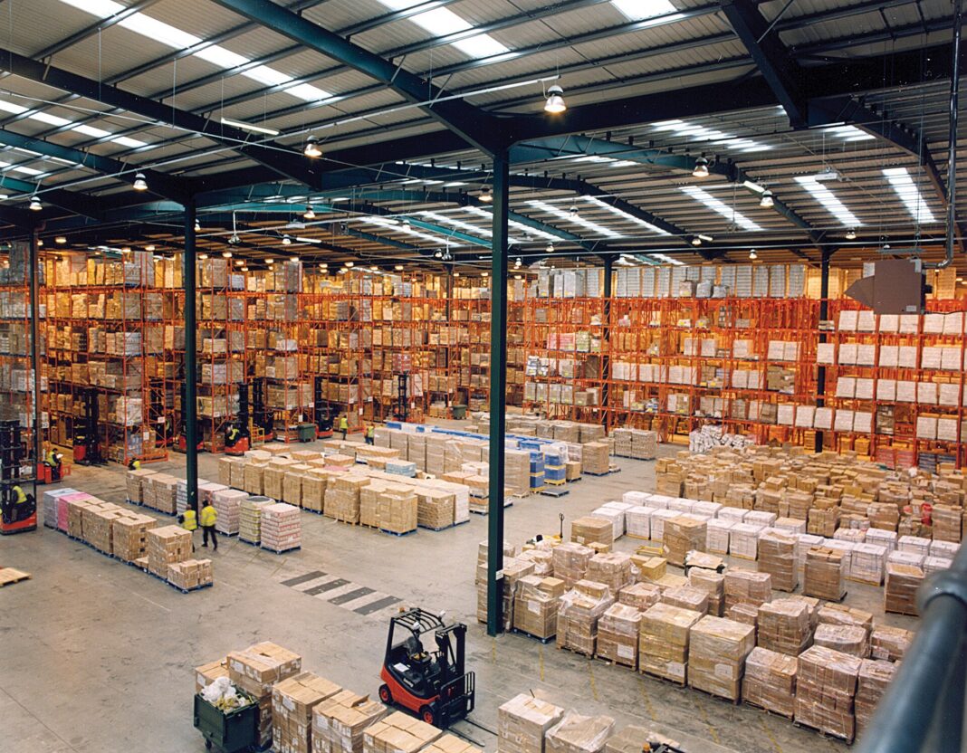 Interior de un centro de distribución con estanterías de paletización y montacargas