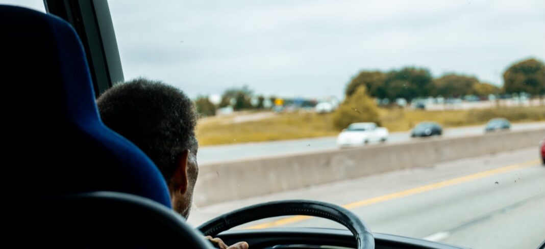 Conductor de autobús de pasajeros al volante en una autopista