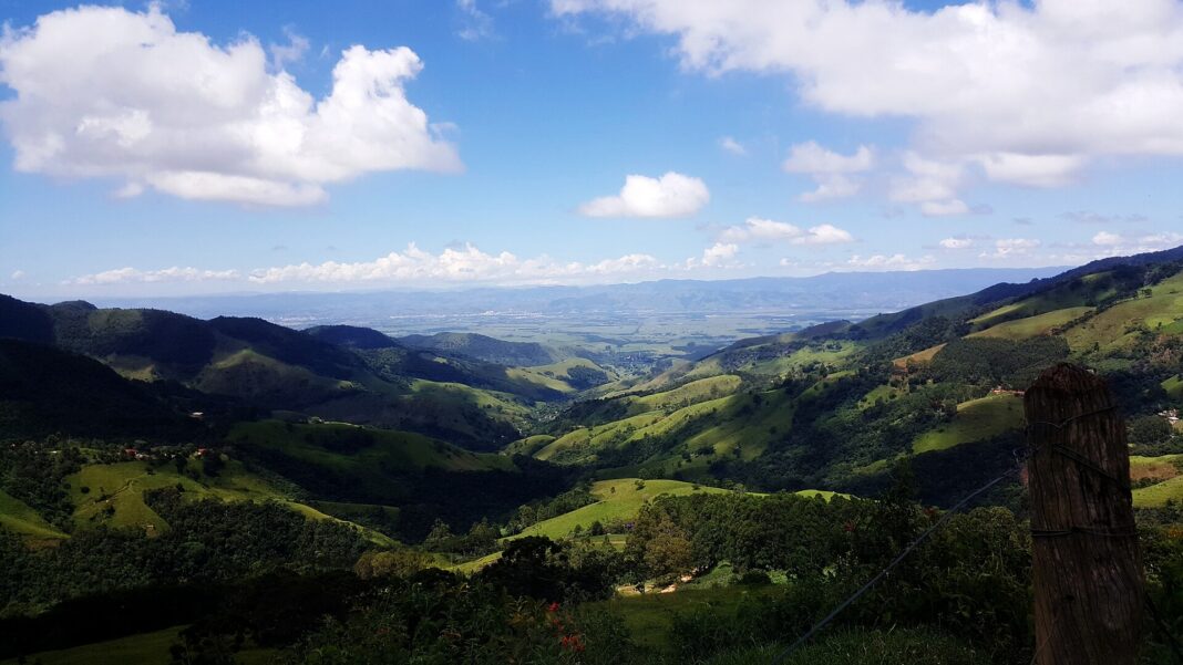 Vista desde lo alto de la Serra da Mantiqueira hacia el valle de Paraíba, con colinas verdes y la ciudad de Aparecida al fondo