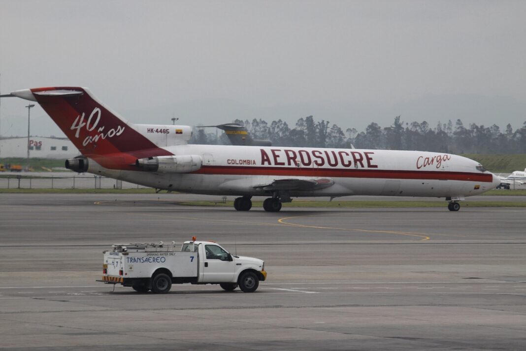 Avión carguero Boeing 727 de Aerosucre rodando en el aeropuerto El Dorado de Bogotá con una camioneta de servicio en primer plano