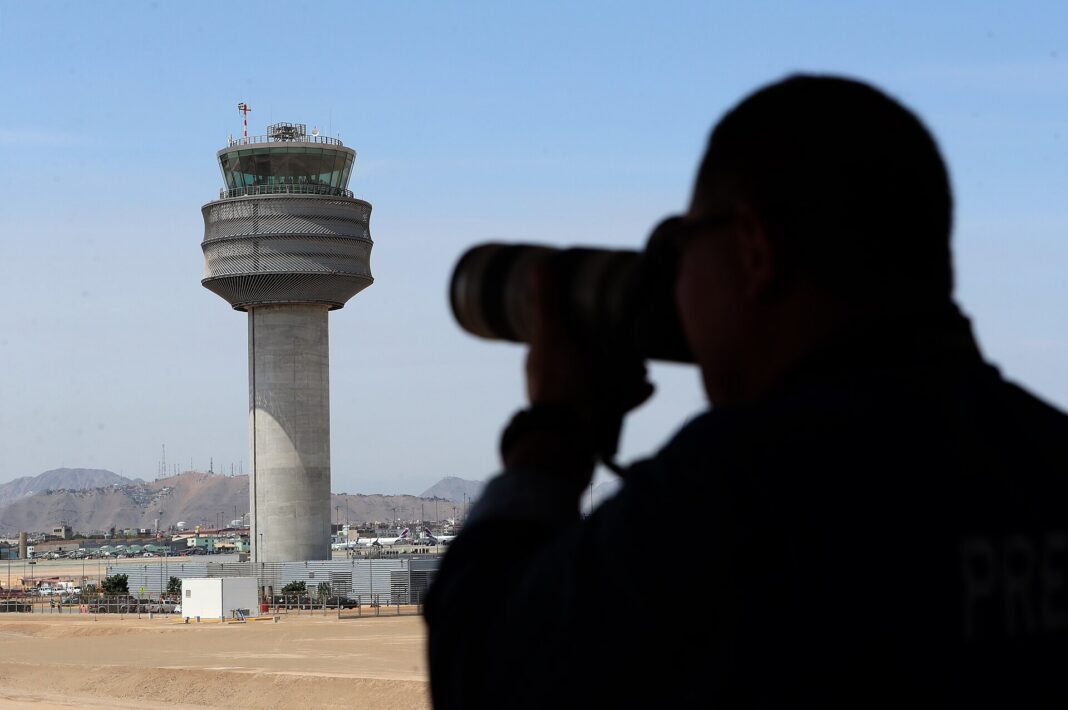 Torre de control del nuevo aeropuerto Jorge Chávez de Lima con un fotógrafo en primer plano