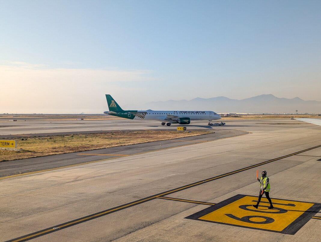 Avión Embraer E195-E2 de Mexicana con cola verde rodando en la pista del AIFA