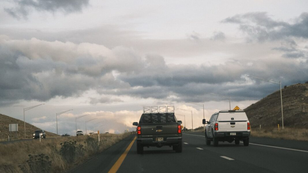 Dos camionetas pickup circulan por una autopista de Estados Unidos bajo un cielo nublado