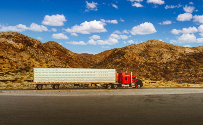 El diésel llegó a 6,53 dólares por galón en Estados Unidos y Trump dice que decidirá Tractocamión rojo con remolque plateado en una carretera del desierto de Nevada