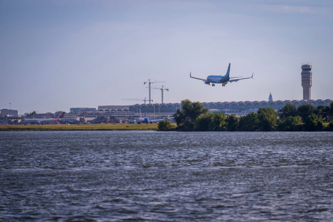 Avión en aproximación al aeropuerto Reagan National de Washington, con la torre de control al fondo y el río Potomac