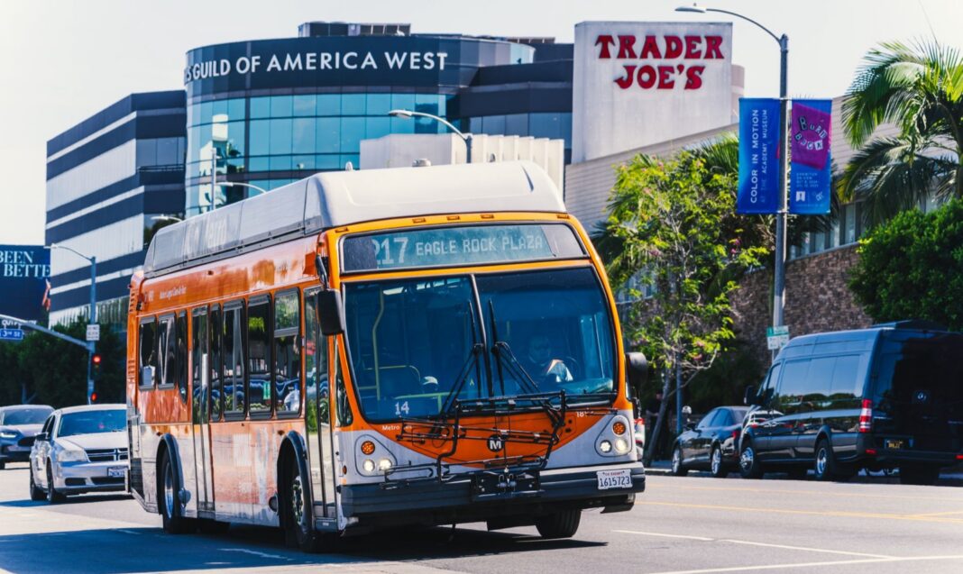 Autobús naranja de Metro de Los Ángeles circulando por una avenida con palmeras