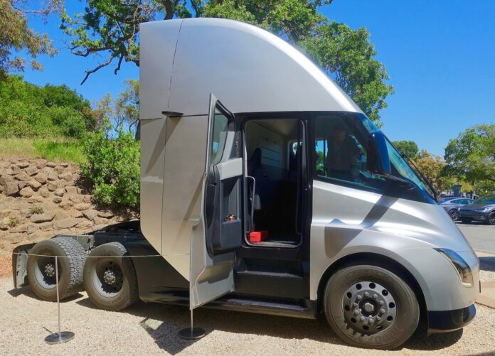 Tesla abre en Nevada la planta del Semi para 50.000 camiones al año y entrega las primeras unidades a PepsiCo, DHL y US Foods Tractocamión eléctrico Tesla Semi plateado con la puerta de la cabina abierta