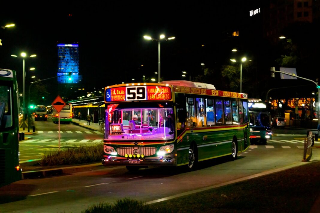 Colectivo de la línea 59 circula de noche por una avenida de Buenos Aires