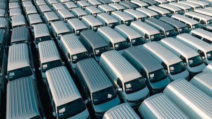 España: Asterion pacta comprar Fraikin y sus 50.000 vehículos Filas de furgonetas blancas estacionadas en una explanada vistas desde arriba
