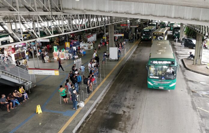 Juez de Bahía revoca arresto por 75 buses retenidos en Salvador Buses urbanos verdes entran a la terminal de Pirajá, en Salvador, mientras pasajeros esperan en el andén