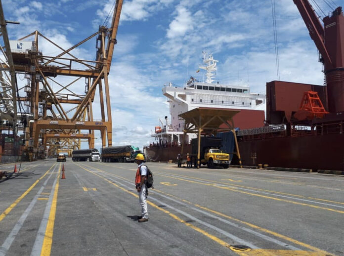 Buenaventura defiende el cobro de $4.235 por tonelada de carga Camiones de carga junto a un buque y grúas en un muelle del puerto de Buenaventura