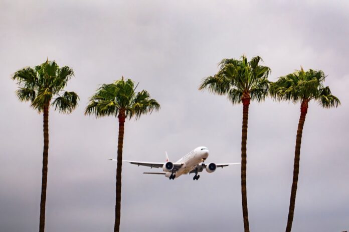 Burbank estrena terminal de US$1.300 M y retira la de 1930 Avión de pasajeros en aproximación entre cuatro palmeras bajo un cielo nublado en el sur de California