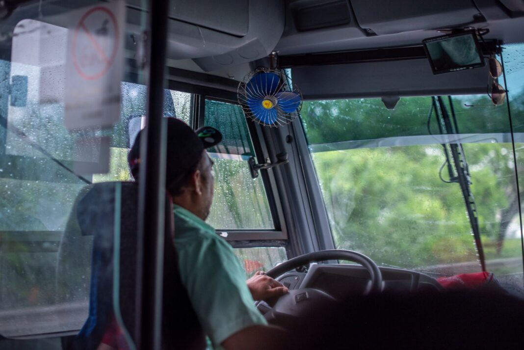 Conductor de autobús urbano al volante visto desde el interior del vehículo