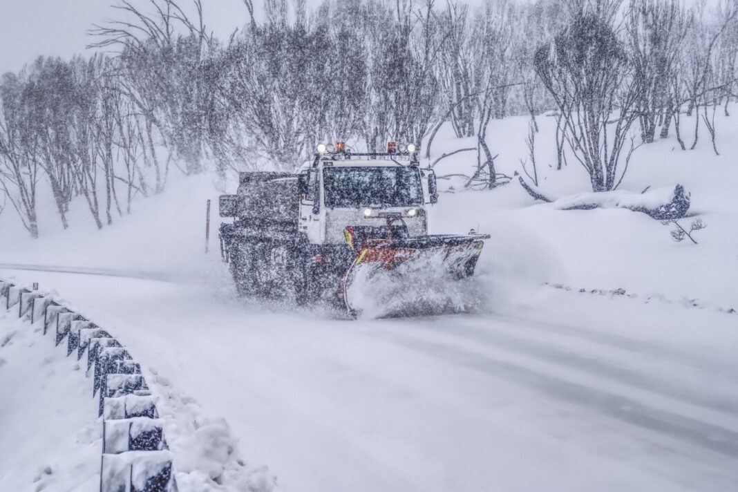 Máquina quitanieves despeja una ruta de montaña durante una nevada