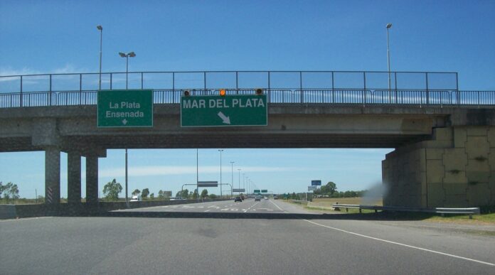 Dock Sud: Aubasa estrena pórtico free flow y multa hasta $684.300 Autopista Buenos Aires-La Plata a la altura de Hudson, con los carteles hacia La Plata, Ensenada y Mar del Plata bajo un puente