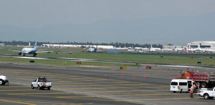 EE.UU. quita el veto a nuevas rutas desde AICM y AIFA tras un año Aviones despegan y aterrizan en las pistas paralelas del aeropuerto de la Ciudad de México, con vehículos de servicio en la plataforma