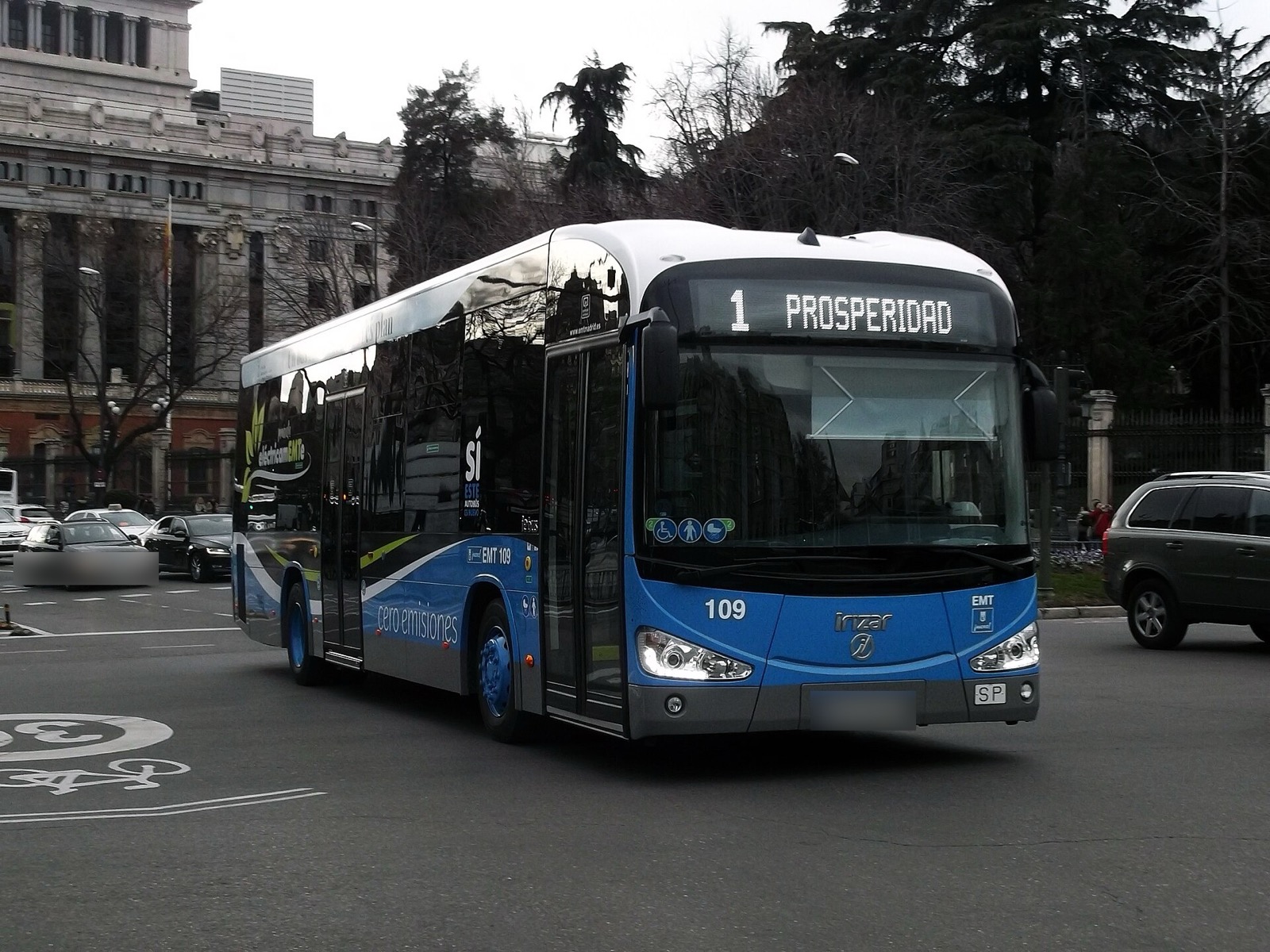 Autobús eléctrico azul de la EMT de Madrid circulando por una plaza del centro de la ciudad