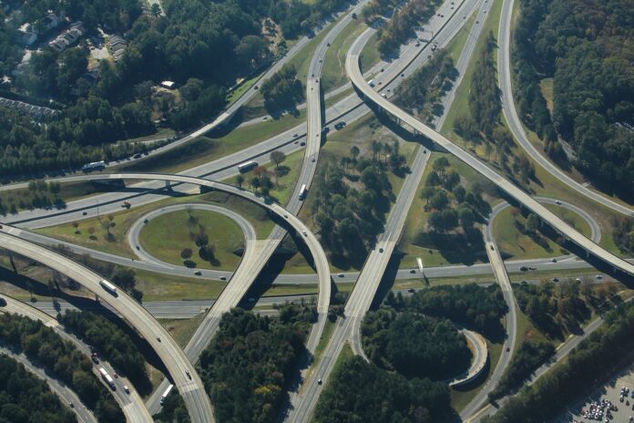 Atlanta: Ferrovial gana la I-285 y pagará US$23.600 millones Vista aérea del enlace entre la I-85 y la I-285 en el norte de Atlanta, con rampas elevadas y camiones