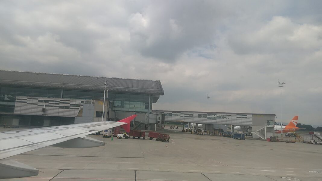 Plataforma del aeropuerto El Dorado de Bogotá bajo un cielo nublado, vista desde un avión