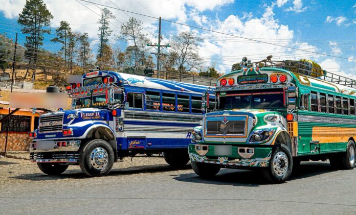 Guatemala: los buses no bajan el pasaje pese al diésel sin IVA Dos buses extraurbanos decorados estacionados en Guatemala