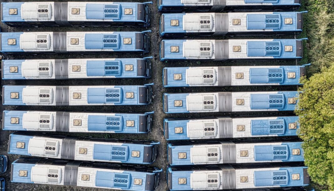 Autobuses estacionados en fila vistos desde arriba, sin circular