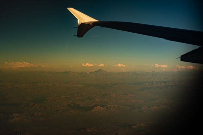 Venezuela: LATAM volverá a volar directo Santiago-Caracas en 2027 Ala de un avión comercial sobre montañas del norte de Chile al atardecer