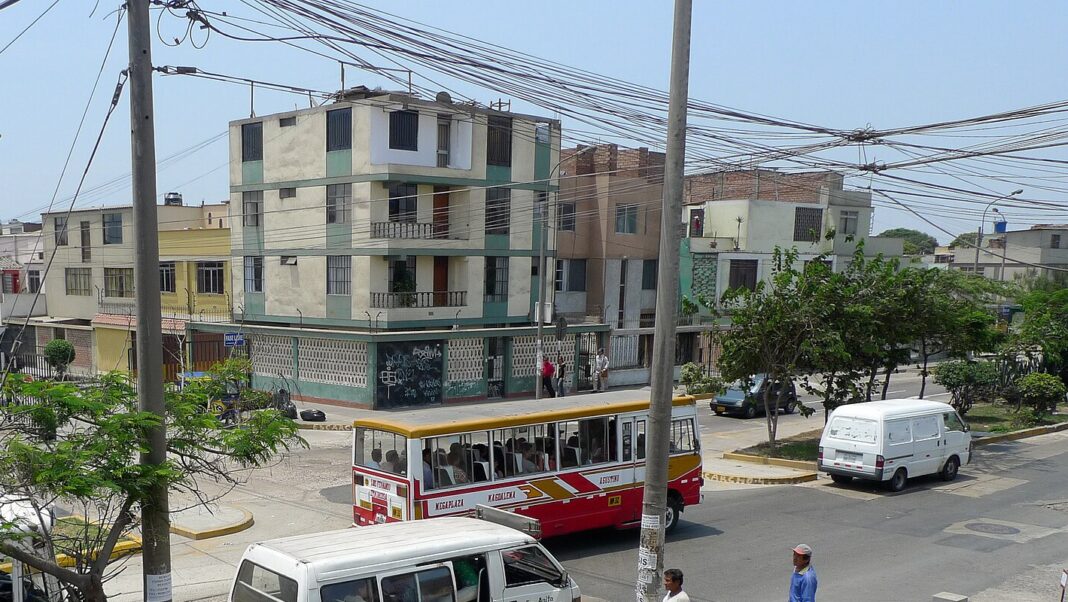 Micro de transporte público y combi en una calle residencial de Lima