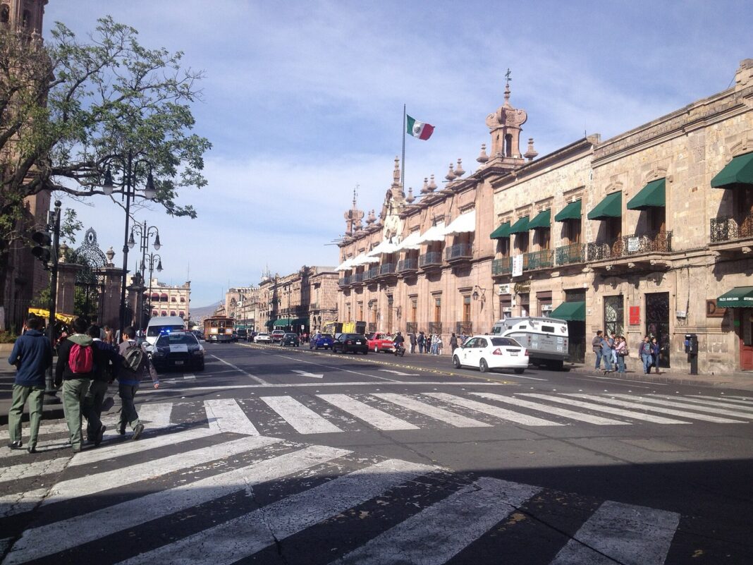 Avenida Madero en el centro de Morelia con taxis y autos frente a edificios de cantera rosa