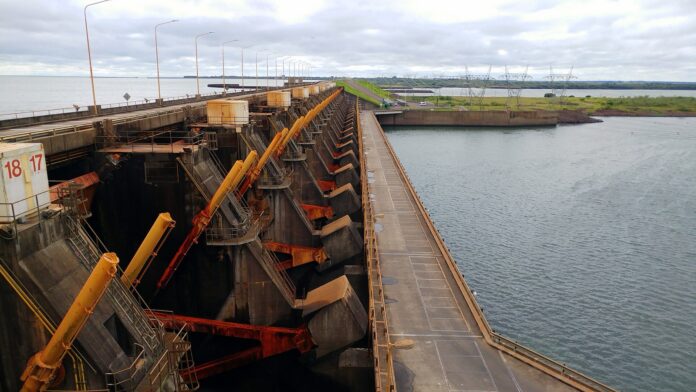Paraguay: la crecida cierra el paso de Yacyretá y 10 puertos Compuertas del vertedero de la represa de Yacyretá junto a la calzada del coronamiento, con el embalse a la derecha