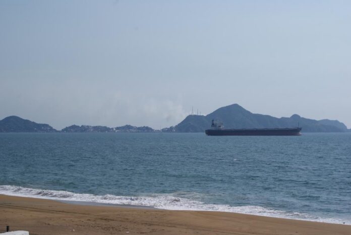Puerto de Manzanillo: Trudy lo cierra una semana después de Simón Buque granelero fondeado frente a la playa de Manzanillo, con los cerros y la ciudad al fondo