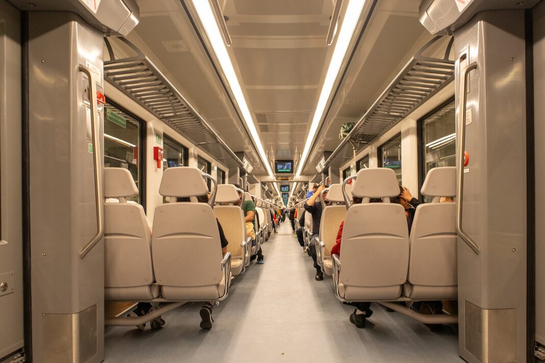 Interior de un vagón del tren Buenavista-AIFA con pasajeros sentados