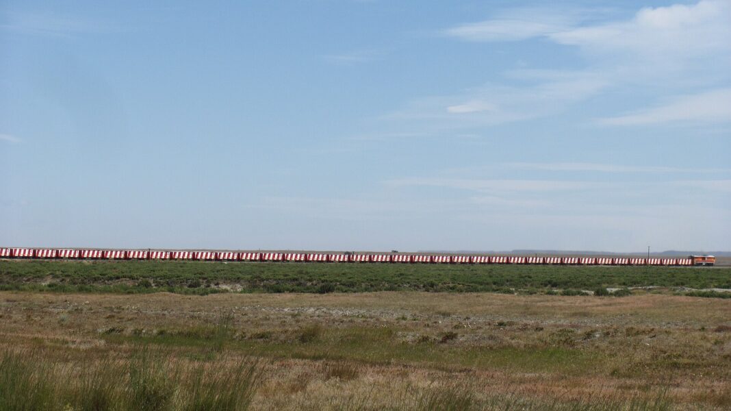 Tren de carbón con vagones rojos y blancos cruza la estepa de Santa Cruz, Argentina